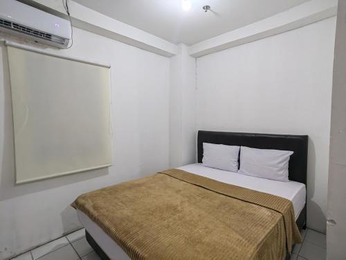 a bedroom with a bed and a flat screen tv at Mailbox Arsakha Lobi B Cibubur Village in Cibubur