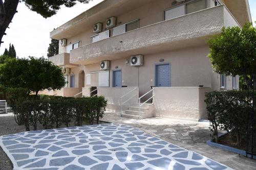 a building with a stone floor in front of it at Studios Αποστόλης Selianitika in Aígio