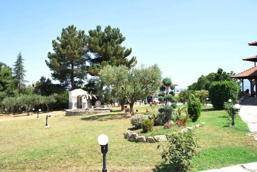 a garden with a gazebo and a park with trees at Archontiko Alexandros Luxury Suites in Kardiá