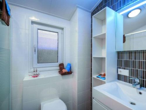 a bathroom with a toilet and a sink and a mirror at Mobile home Chatel 'Hotelzimmer' in Fehmarn