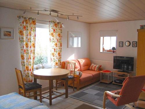 a living room with a couch and a table at LUV and LEE Comfortable holiday residence in Wesselburenerkoog