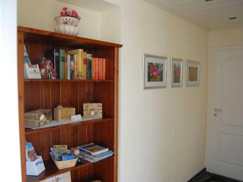 a book shelf filled with books in a room at LUV and LEE Comfortable holiday residence in Wesselburenerkoog