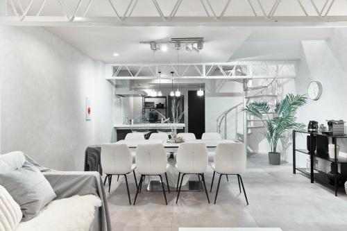 a dining room with a table and white chairs at eni suite tennoji in Osaka