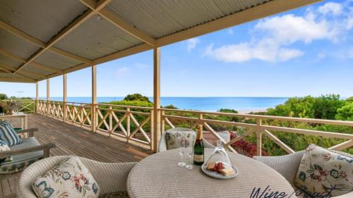 a table with a plate of food on a balcony at Alton House By Wine Coast Holidays in Port Willunga