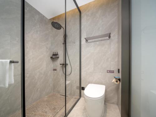 a bathroom with a shower with a toilet at Days Inn by Wyndham Zhuhai Gongbei Port in Zhuhai