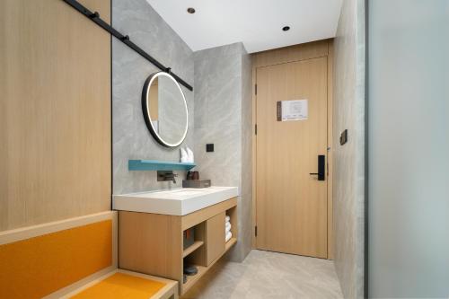a bathroom with a sink and a mirror at Days Inn by Wyndham Zhuhai Gongbei Port in Zhuhai