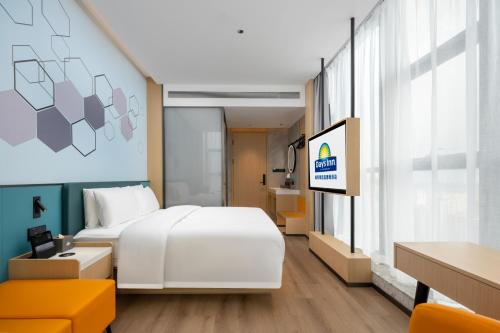 a hotel room with a bed and a tv at Days Inn by Wyndham Zhuhai Gongbei Port in Zhuhai