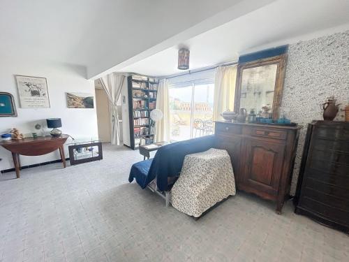a bedroom with a bed and a dresser and a window at RooftopTerrace apartment in village center in Cargèse