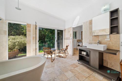 a bathroom with a tub and a sink at Straddie Glasshouse by Discover Stradbroke in Point Lookout