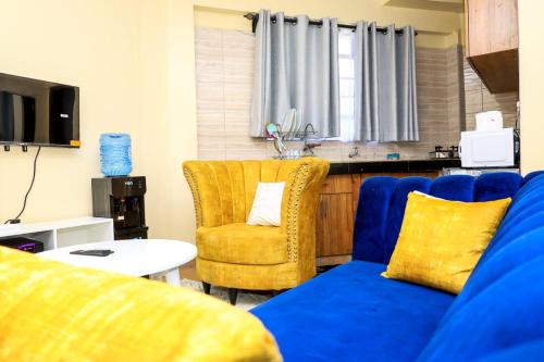 a living room with a blue couch and a chair at Studio Apartment, Kisii in Kisii