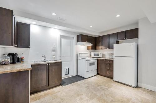 a kitchen with wooden cabinets and a white refrigerator at Private 1 bedroom in Brookswood in Langley