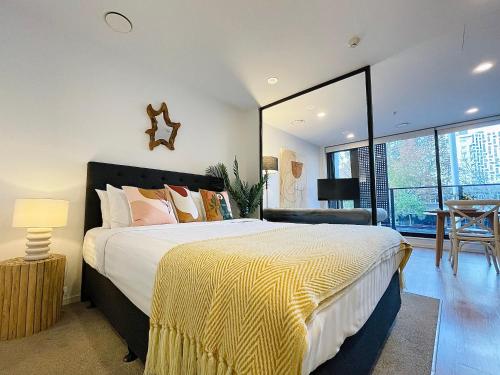 オークランドにあるBeautiful Stylish CBD apartmentのベッドルーム1室(大型ベッド1台、黄色と白の毛布付)