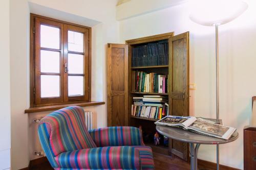 a room with a chair and a table with a book shelf at Casa Marta in Pescaglia