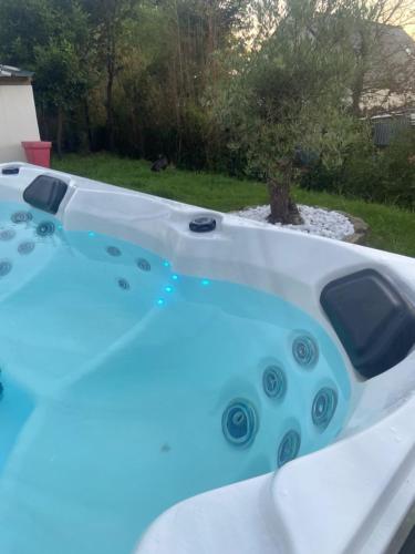 une baignoire blanche avec de l'eau bleue dans une cour dans l'établissement Maison pour 4, Mer et marais salants, Spa, à Guérande