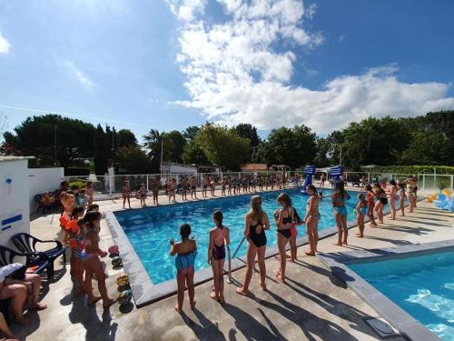 un groupe de personnes debout autour d'une piscine dans l'établissement Charlène Julien, à Meschers-sur-Gironde