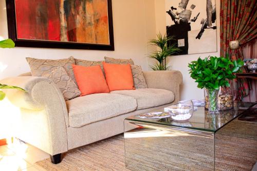 a living room with a couch and a glass table at Olive Country Lodge - Eswatini in Ngwempisi