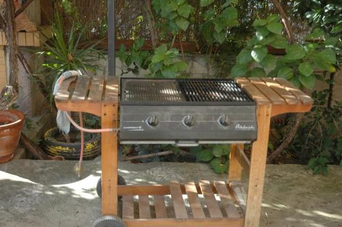 a grill on a wooden stand with a chair at Mare - Mare B in Patra