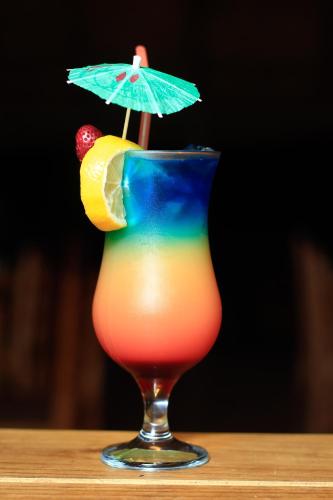 a colorful drink with an umbrella on a table at Olive Country Lodge - Eswatini in Ngwempisi