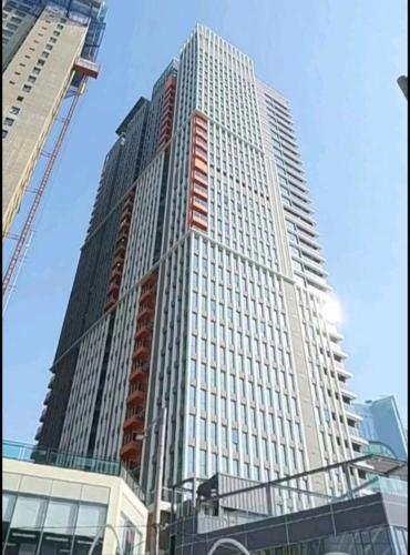 a tall building with a crane in front of it at Elbon the stay with A1 in Busan