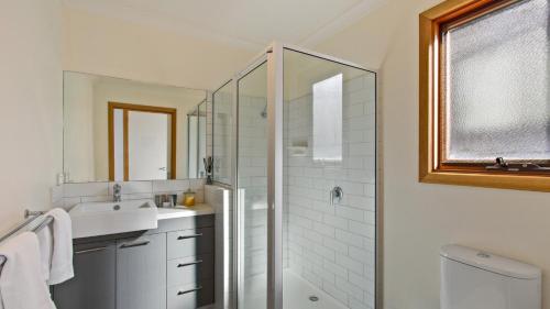 a white bathroom with a sink and a shower at Secret Hut in Dinner Plain