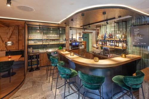 a bar in a restaurant with green stools at Hotel Walliserstube in Damuls