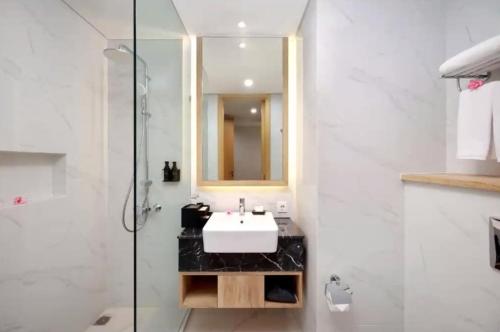 a bathroom with a sink and a glass shower at Anagata Tanjung Benoa Bali in Nusa Dua