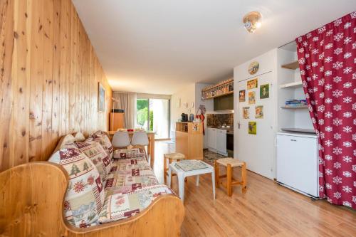 un salon avec un canapé et une cuisine dans l'établissement Petit Montagnard - Casier à ski - Parking, à Enchastrayes