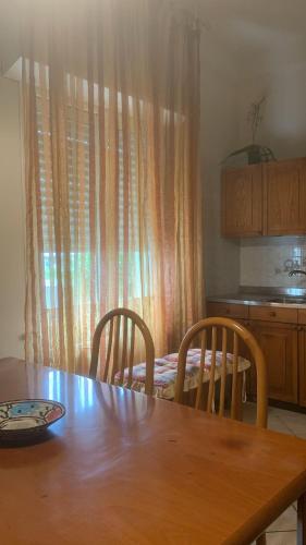 a dining room table with two chairs and a kitchen at Hotel Rosati in Rimini