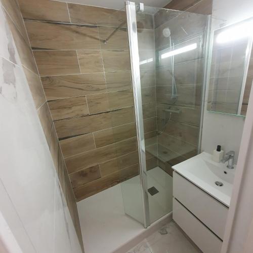 une salle de bain avec douche et lavabo dans l'établissement Oceanes appartement vue mer, à Pornichet