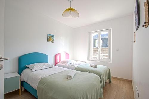 deux lits jumeaux dans une chambre avec fenêtre dans l'établissement La Cabane de Plage, à Étretat