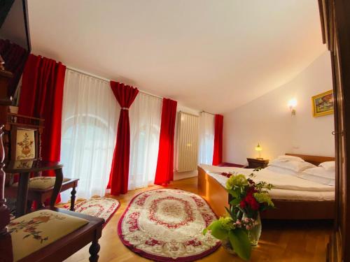 a bedroom with two beds and red curtains at Rapsodia Pension in Suceava