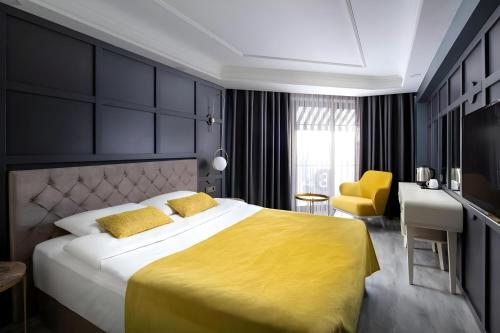 a bedroom with a large bed with a yellow blanket at B LOFT HOTEL in Bursa