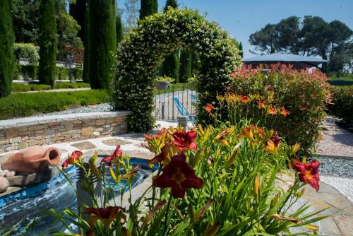 a garden with a fountain and flowers in the foreground at Casale al Foino in Induno Olona