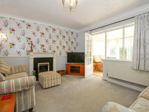 a living room with a fireplace and a television at Potter's Retreat in Dersingham