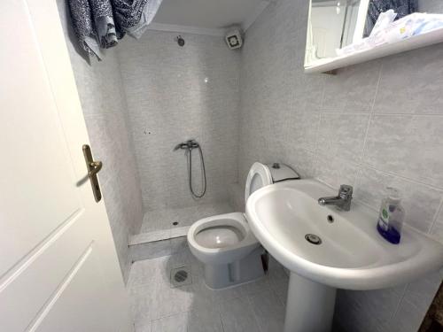 a white bathroom with a toilet and a sink at Elia House in Pefkohori