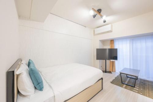 a bedroom with a bed and a flat screen tv at Grand Concierge Roppongi in Tokyo
