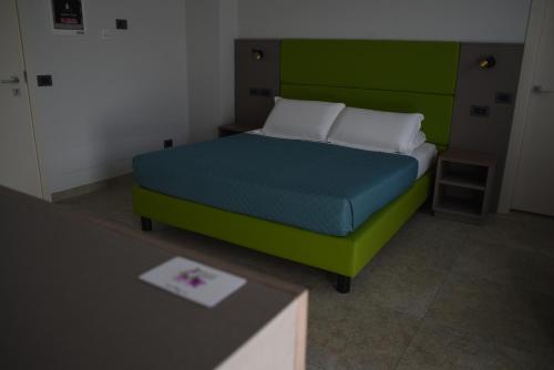 a bed with a green headboard in a room at Casale al Foino in Induno Olona