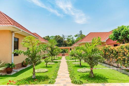 a garden in front of a house with trees at Lindrin lodge moshi in Shiri