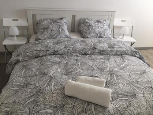 Raon-lʼÉtapeにあるUne étape à Raonの大型ベッド(グレーと白の掛け布団付)