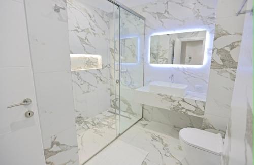 a bathroom with a toilet and a sink and a shower at Ambient Apartaments in Durrës