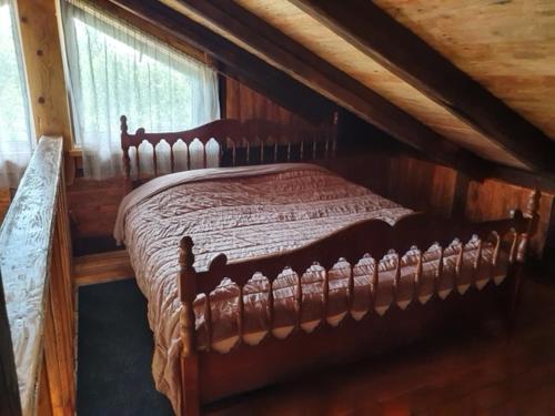 a bedroom with a wooden bed in a attic at Auci Guest house 2 in Liepāja