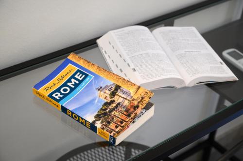 an open book on a table next to a book at GuestHouse o Affittacamere Magenta Baylon Suite in Rome