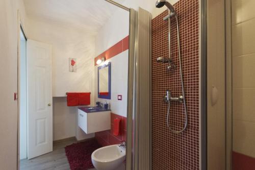 een badkamer met een douche, een wastafel en een toilet bij L'Attico in Rende