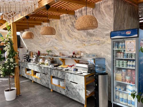 a restaurant kitchen with a counter with food at Ilio Boutique Hotel in Ksamil