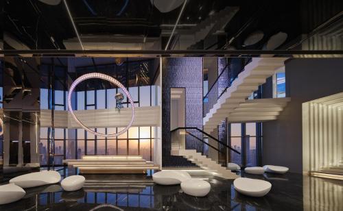 a lobby with a spiral staircase and white chairs at ISEYA Panoramic Hotel Chongqing Jiefangbei Raffles Plaza in Chongqing