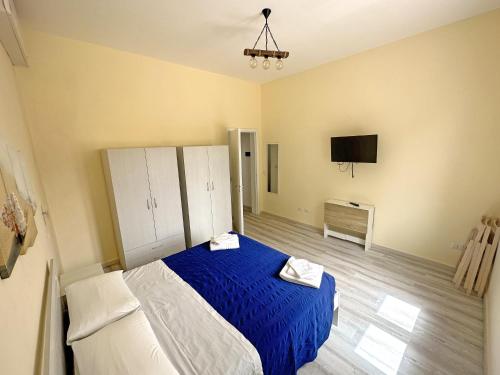 una camera con letto blu e TV di Dimora Rem Country Life a 2 minuti dal mare a Nardò