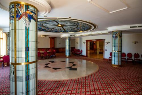a large room with a lobby with a stained glass ceiling at Hotel Golden Palace in Göd