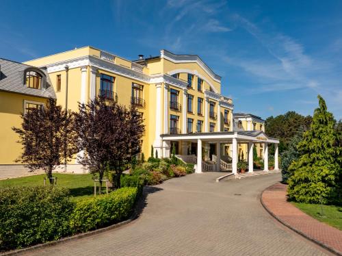 a large yellow building with a gazebo at Hotel Golden Palace in Göd