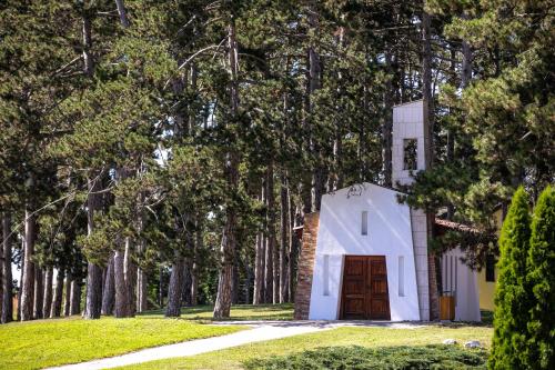 a small white chapel in a forest of trees at Hotel Golden Palace in Göd