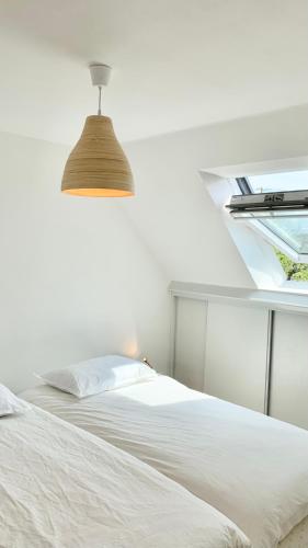 - une chambre avec un lit blanc et un plafond dans l'établissement Dépendance bord de mer, à Plozévet